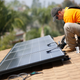 Vivint Solar technician Eduardo Aguilar installs solar panels on the roof of a house in Mission Viejo, California October 25, 2013.
